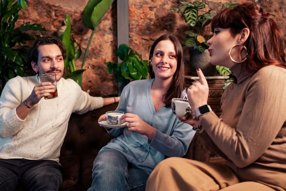 Grupo de pessoas compartilhando chá e doces em uma tarde de convívio social