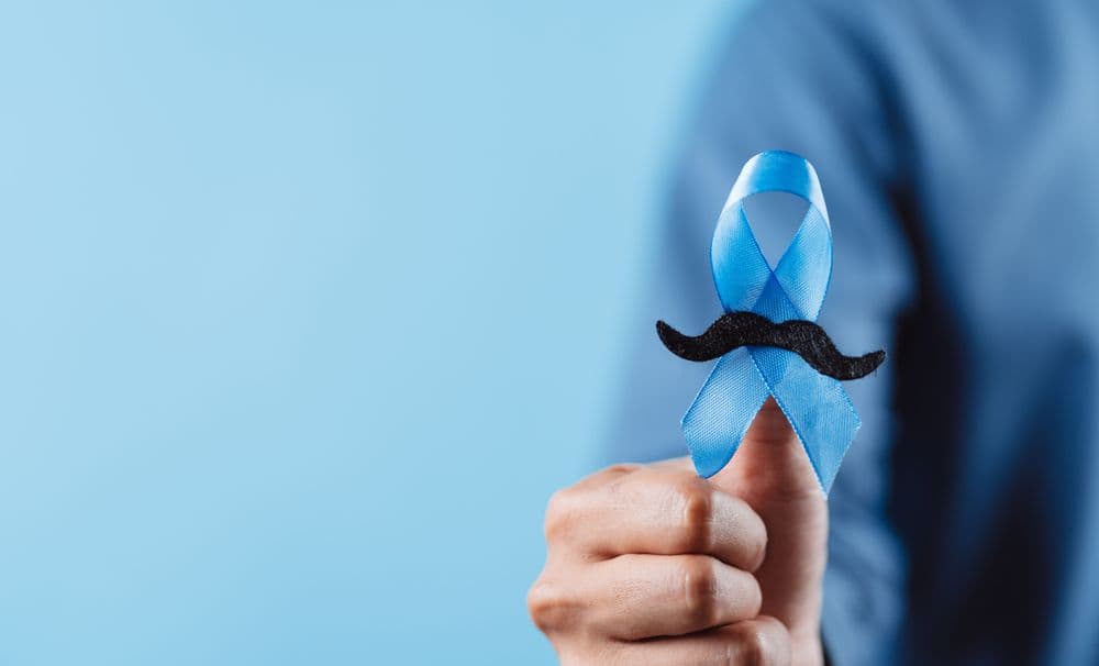 Fita azul com bigode simbolizando o Novembro Azul e a prevenção do câncer de próstata.