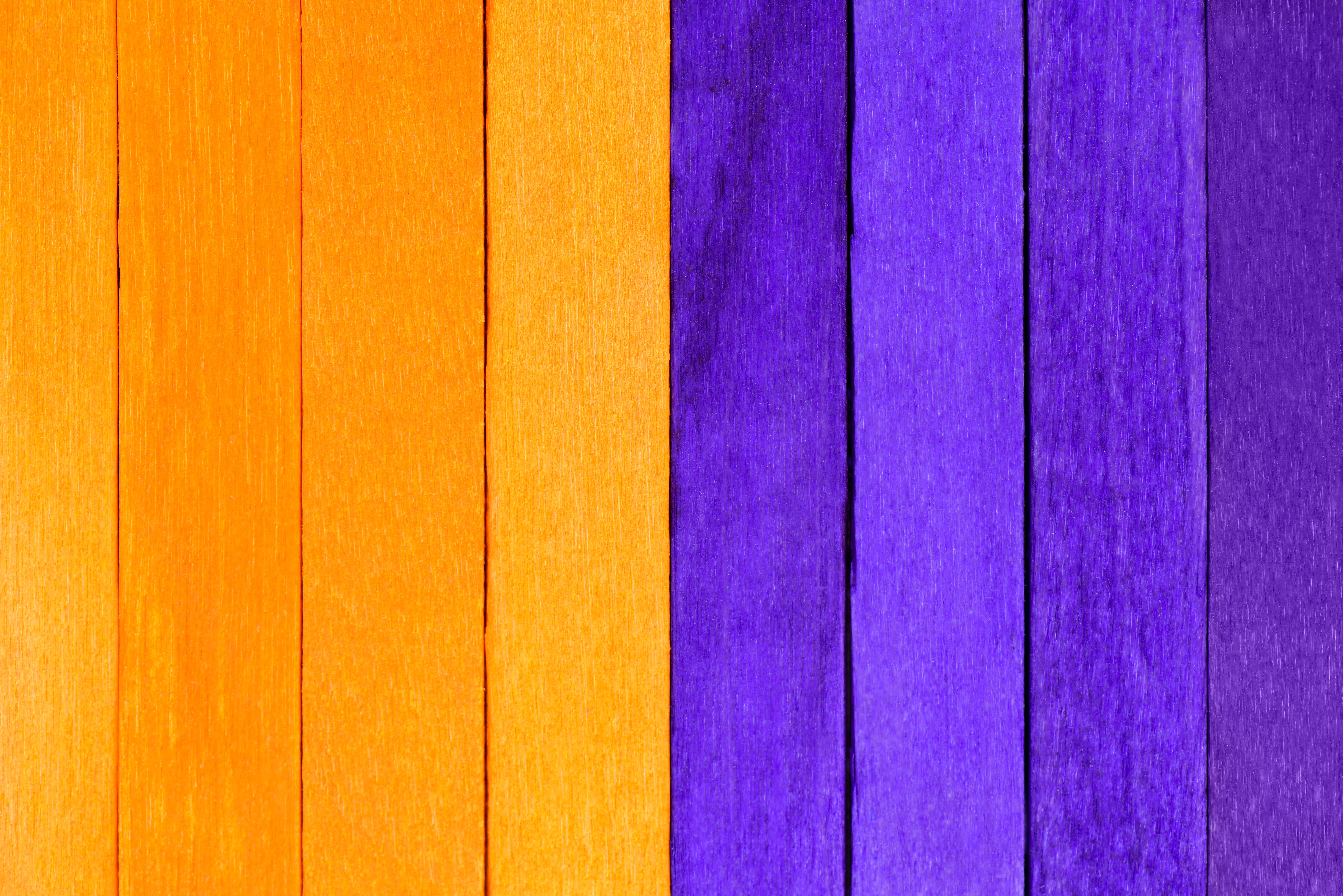 Textura de madeira com faixas laranja e roxas simbolizando a campanha Fevereiro Roxo e Laranja.