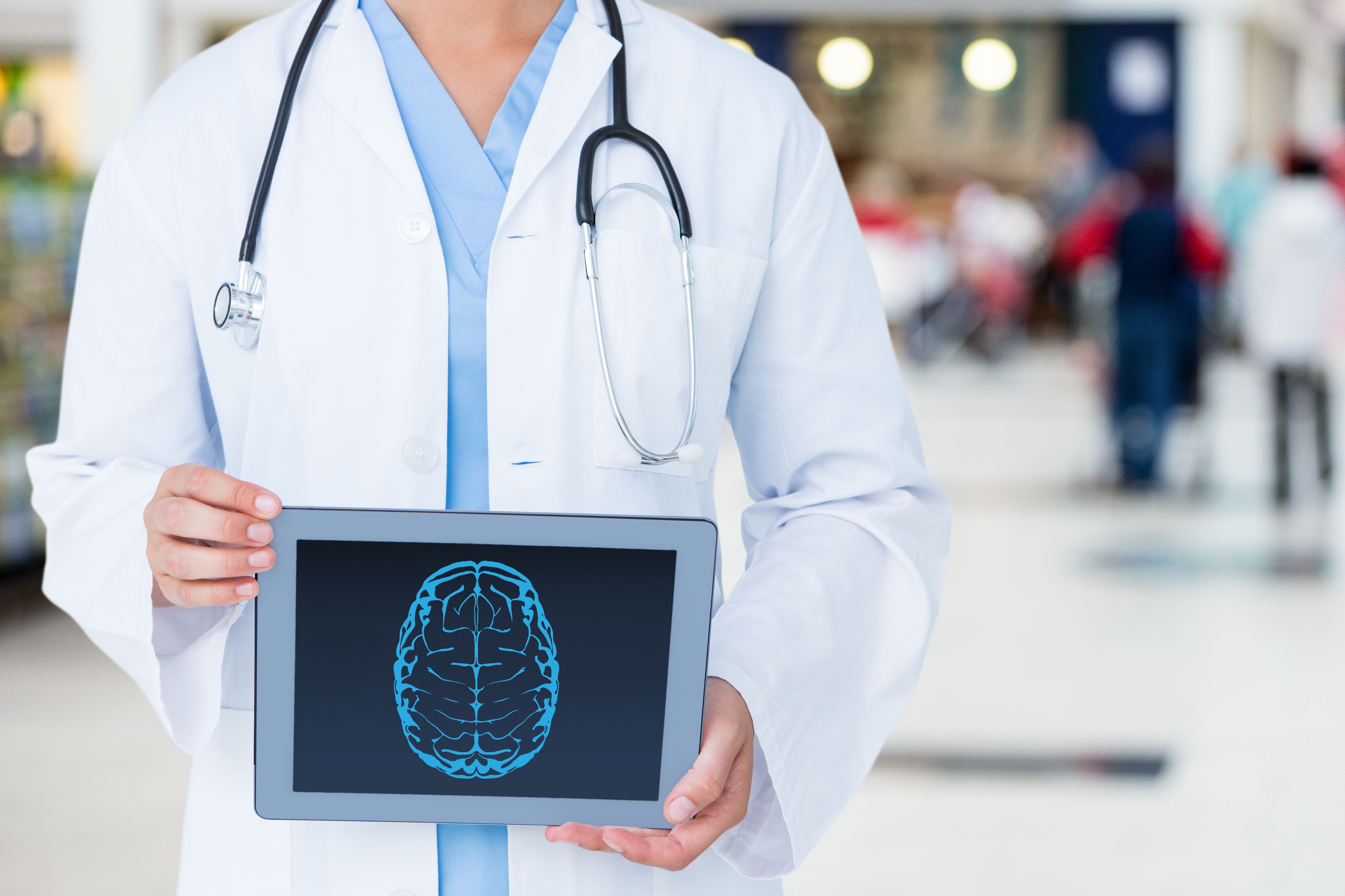 Médico segurando um tablet com imagem de cérebro, representando saúde cognitiva e uso de cannabis medicinal.