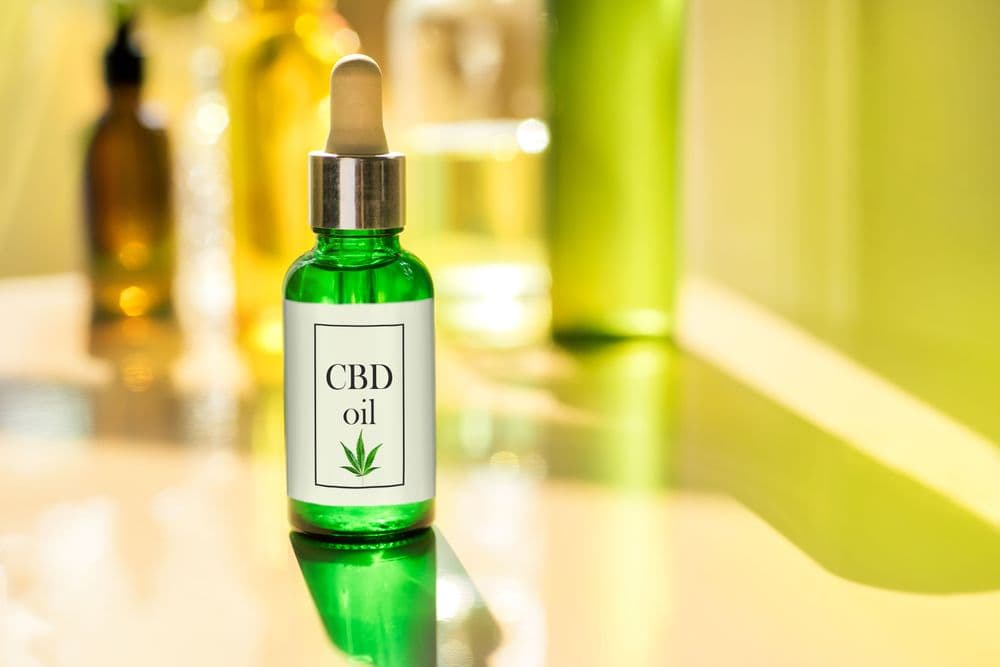 Frasco verde de óleo de CBD com conta-gotas, usado para bem-estar e terapias naturais.